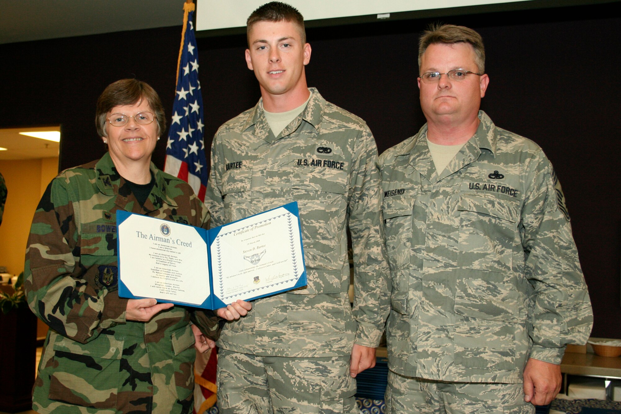 GRISSOM AIR RESERVE BASE, Ind., -- Airman Steven Bartee, 434th Aircraft Maintenance Squadron, receives his first stripe from Col. Betty Bowen, 434th Mission Support Group commander and Chief Master Sgt. Chad Weisend, 434th Maintenance Group superintendent, during a promotion ceremony held during a recent unit training assembly. The quarterly ceremony allows Airmen, and NCOs an opportunity to be recognized for their advancement. (U.S. Air Force photo/Tech. Sgt. Patrick Kuminecz)