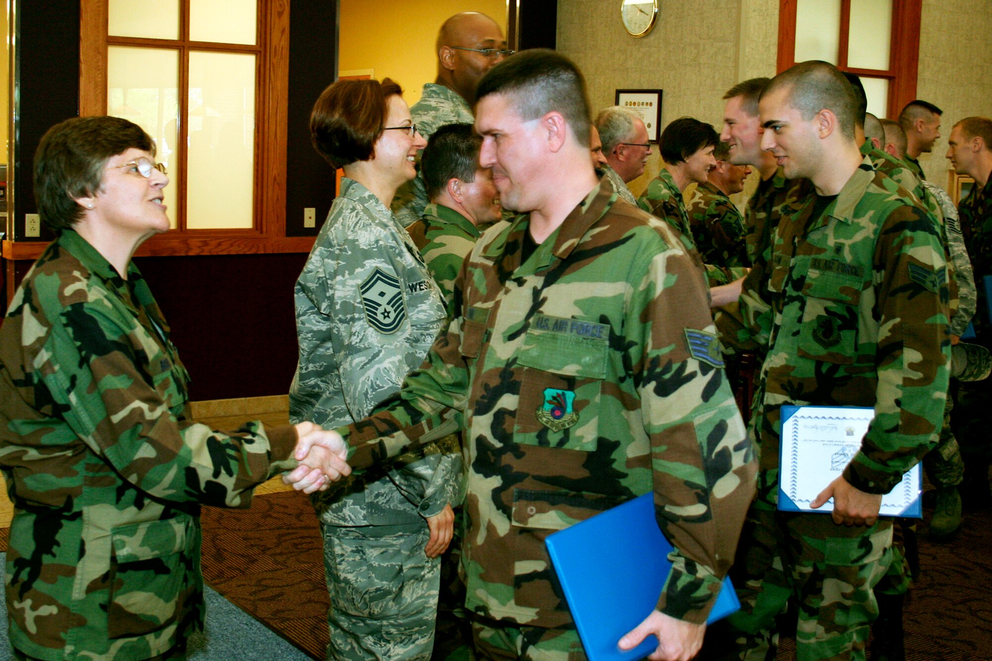 GRISSOM AIR RESERVE BASE, Ind., -- Col. Betty Bowen, 434th Mission Support Group commander, left, greets Staff Sgt. John Moore, a communications navigation systems specialist, as he and other new promotees make their way down the reception line at the quarterly promotion ceremony held during a recent unit training assembly. (U.S. Air Force photo/Tech. Sgt. Patrick Kuminecz)
