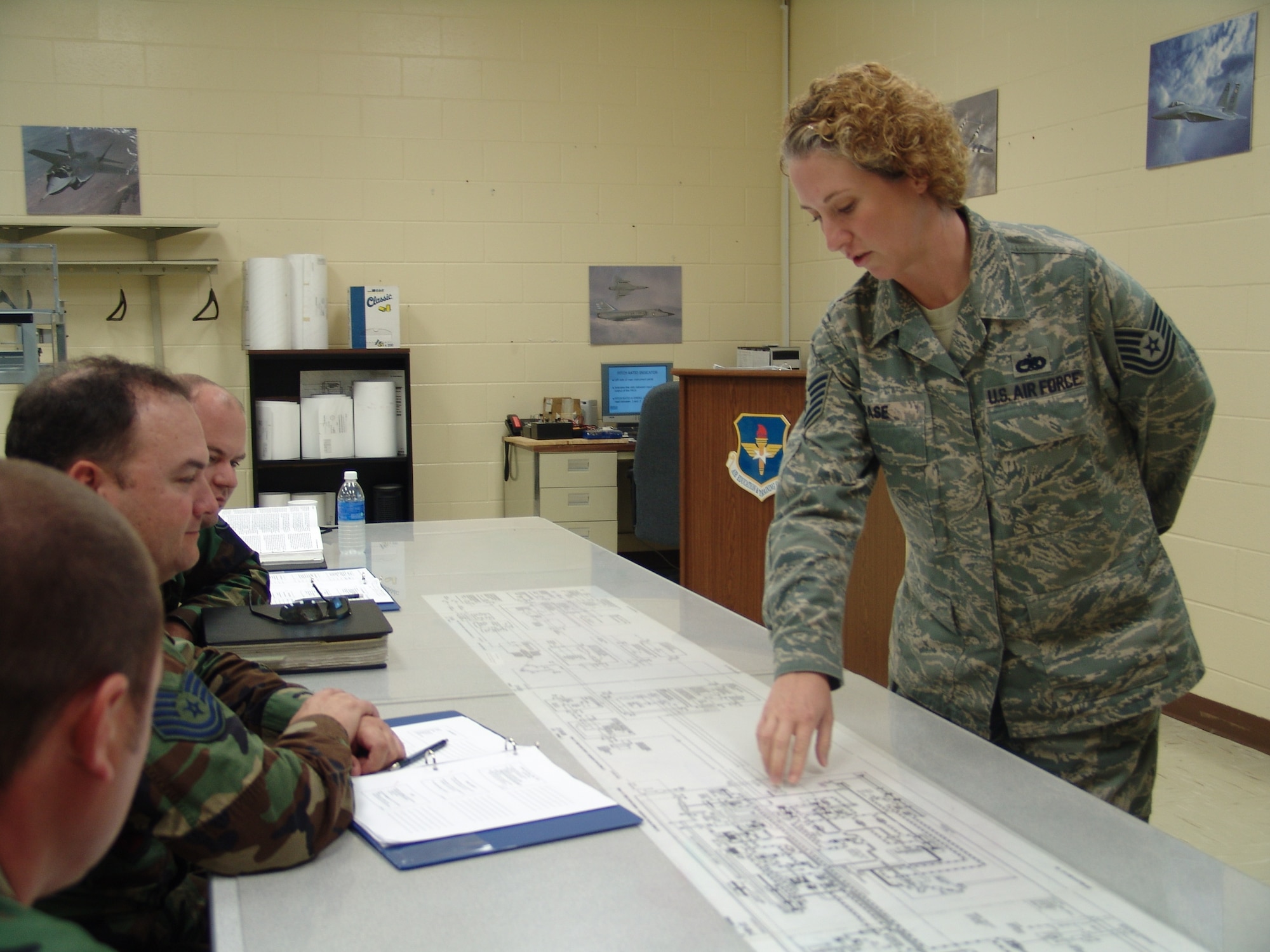 Tech Sgt. Candra Case, 372nd Training Detachment, instructs F-15 Eagle crew members on aircraft maintenance.