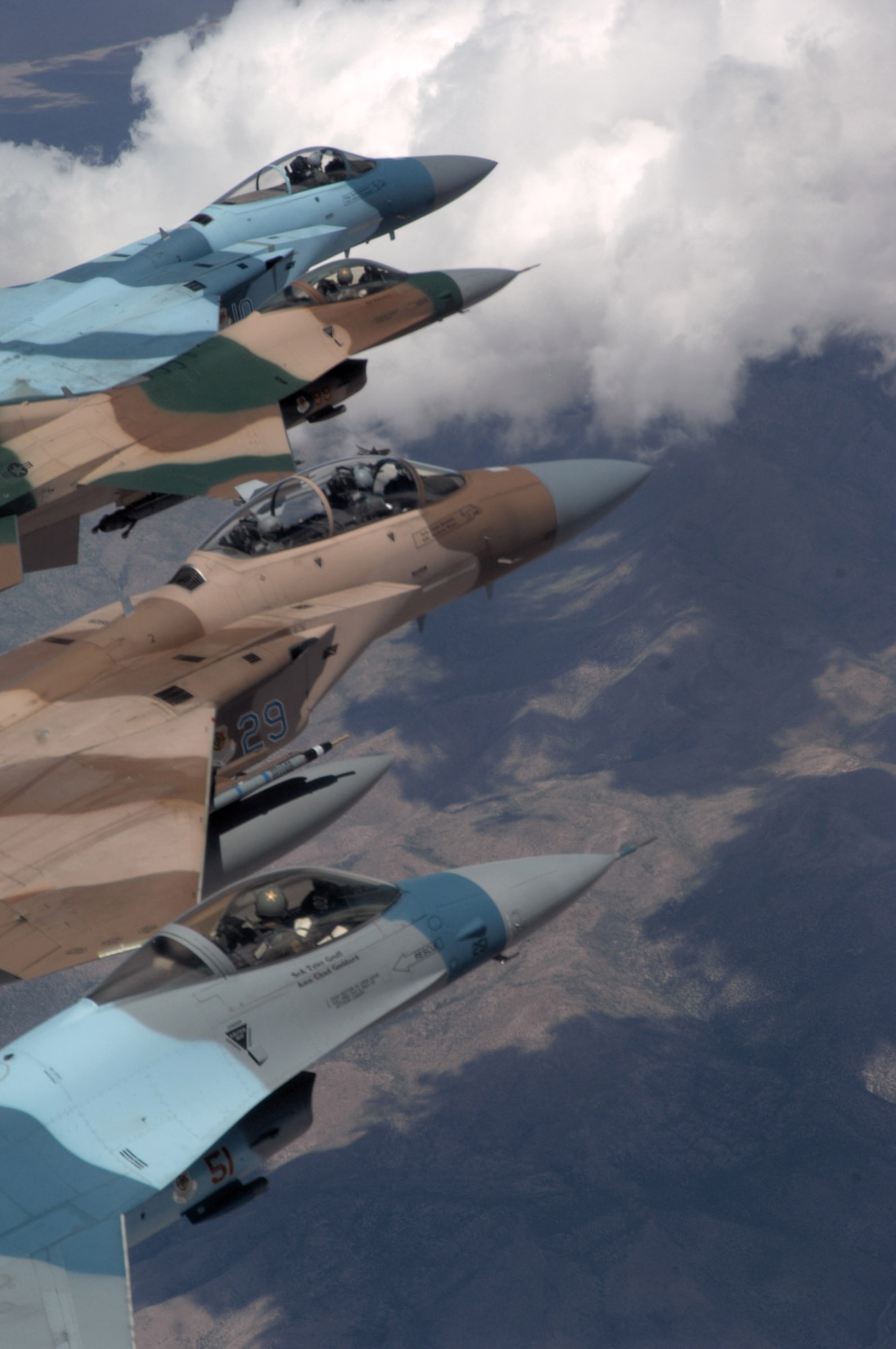 A flight of Aggressor F-15 Eagles and F-16 Fighting Falcons fly in formation June 5 over the Nevada Test and Training Range. The jets are assigned to the 64th and 65th Aggressor squadrons at Nellis Air Force Base, Nev. The F-15's air superiority is achieved through a mixture of unprecedented maneuverability and acceleration, range, weapons and avionics. The F-16's maneuverability and combat radius (distance it can fly to enter air combat, stay, fight and return) exceeds that of all potential threat fighter aircraft. (U.S. Air Force photo/Master Sgt. Kevin J. Gruenwald) 
