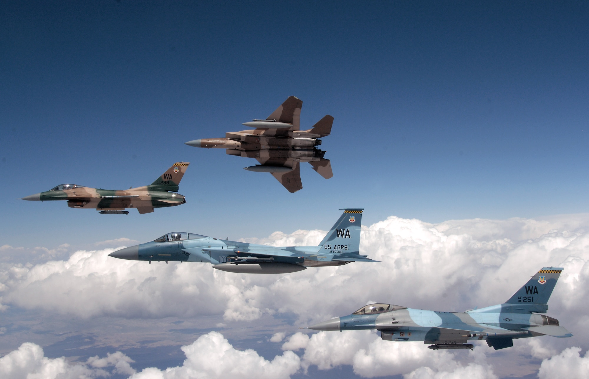 A flight of Aggressor F-15 Eagles and F-16 Fighting Falcons fly in formation June 5 over the Nevada Test and Training Range. The jets are assigned to the 64th and 65th Aggressor squadrons at Nellis Air Force Base, Nev. The Aggressor mission is to prepare the combat air forces, joint and allied aircrews for tomorrow's victories with challenging and realistic threat replication, training, academics and feedback. (U.S. Air Force photo/Master Sgt. Kevin J. Gruenwald)
