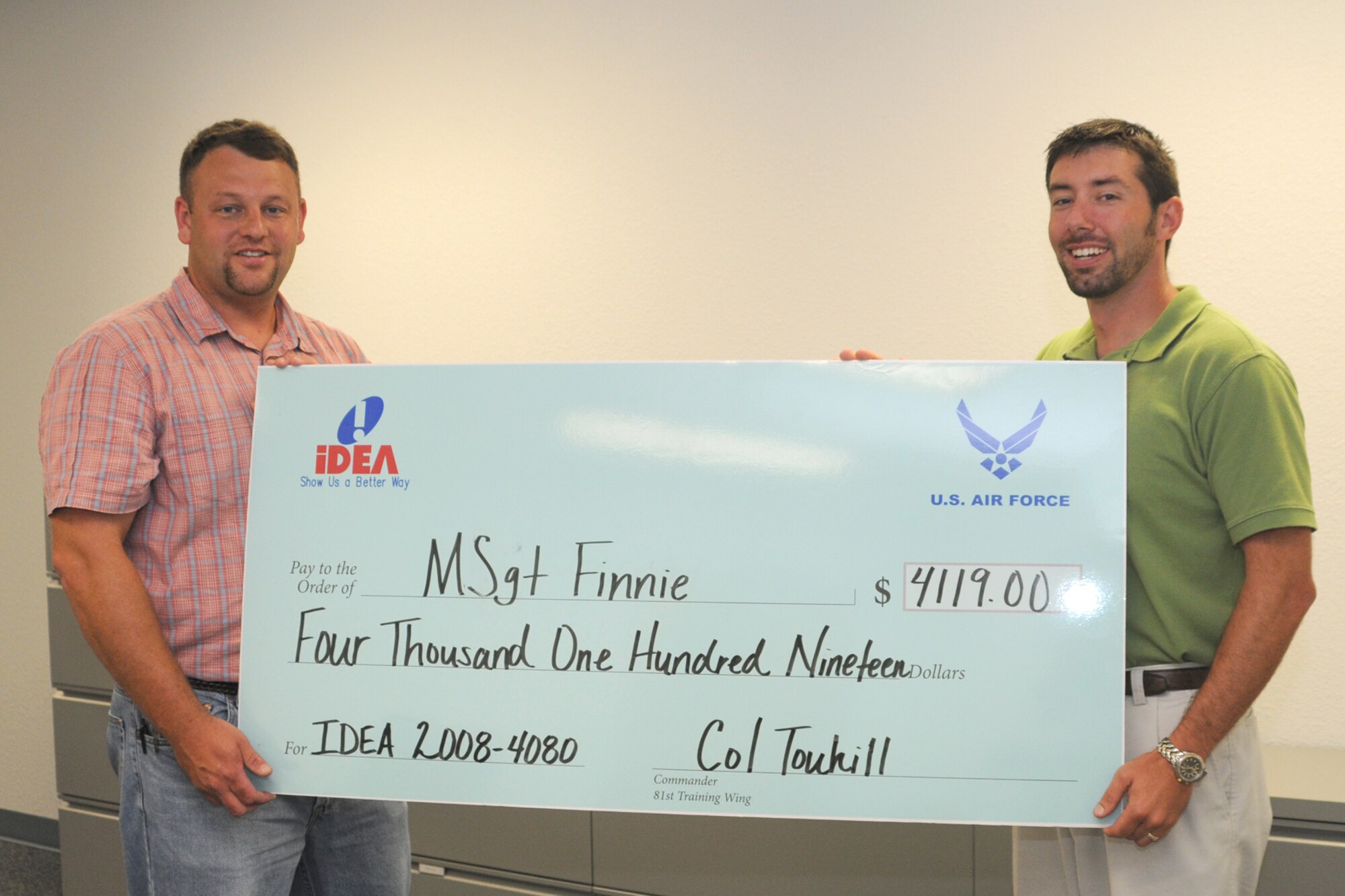 Master Sgt. Len Finnie, left and Mr. John Slusher, 81 MSS pose with the check that was presented to Capt. Apilado. (U.S. Air Force photo by Kemberly Groue)