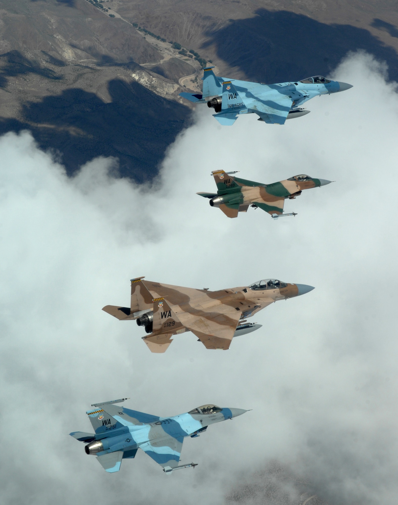 A flight of Aggressor F-15 Eagles and F-16 Fighting Falcons fly in formation June 5 over the Nevada Test and Training Range. The jets are assigned to the 64th and 65th Aggressor squadrons at Nellis Air Force Base, Nev. The F-15 has electronic systems and weaponry to detect, acquire, track and attack enemy aircraft while operating in friendly or enemy-controlled airspace. The F-16 can locate targets in all weather conditions and detect low-flying aircraft in radar ground clutter. (U.S. Air Force photo/Master Sgt. Kevin J. Gruenwald) 