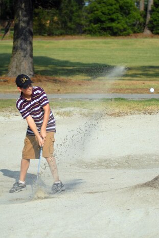 Corey Rawlings, 12, hits a bunker shot on the fifth hole at Wrenwoods Golf Course June 9. (U.S. Air Force photo/Senior Airman Sam Hymas)