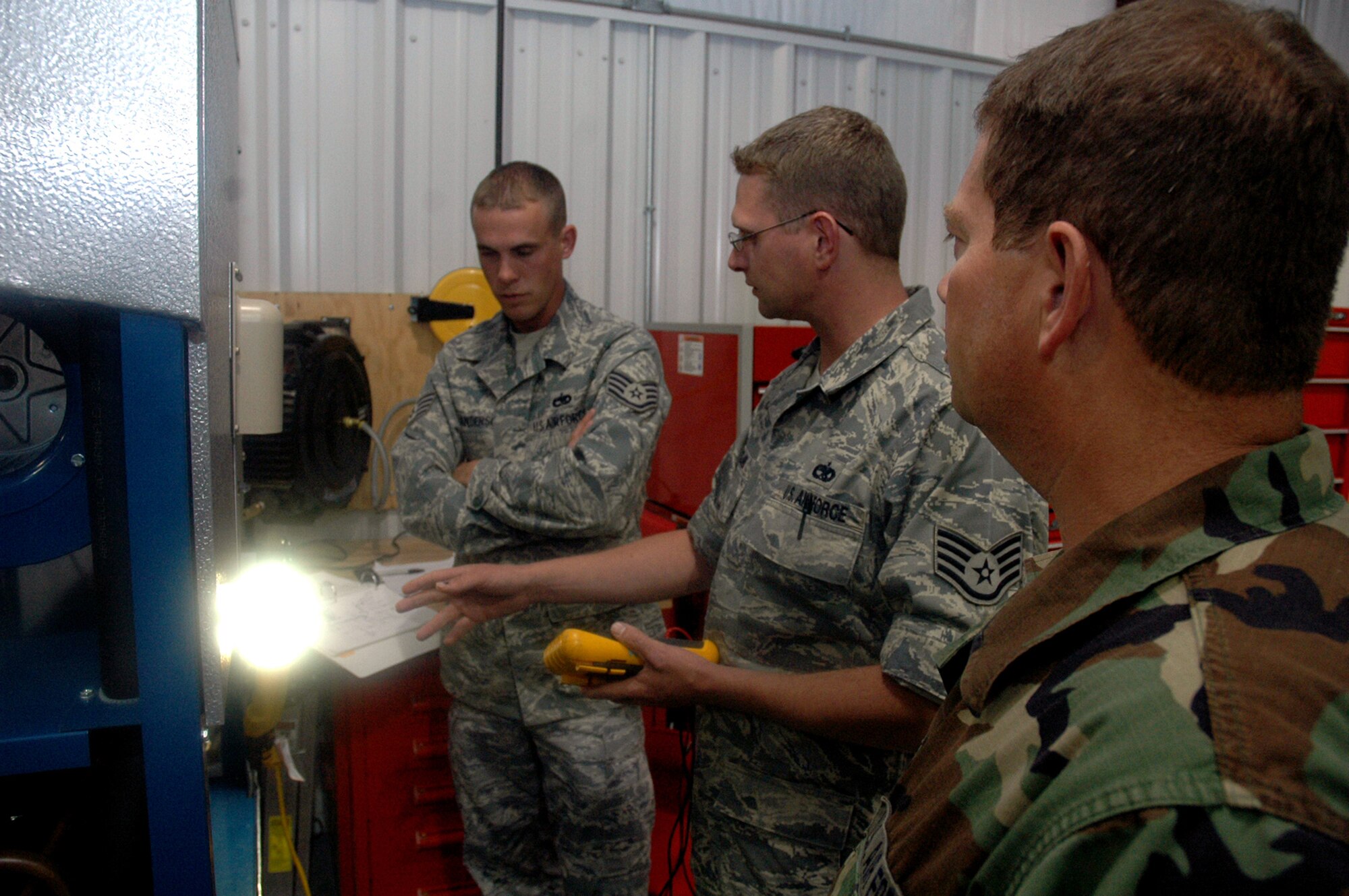 Staff Sgt. Jonathon McClure (center), instructor and course director for the Mobile Command and Control Environmental Control Unit Course for the U.S. Air Force Expeditionary Center's Mobility Operations School at Fort Dix, N.J., goes over technical data with a couple of his students during a class June 5, 2008, at the Center.  Nearly all of Sergeant McClure's students come from contingency response units from across the Air Force.  Annually, the USAF EC trains more than 23,000 students in expeditionary- and mobility air force-based course both with in-residence and distance learning.  (U.S. Air Force Photo/Tech. Sgt. Scott T. Sturkol)