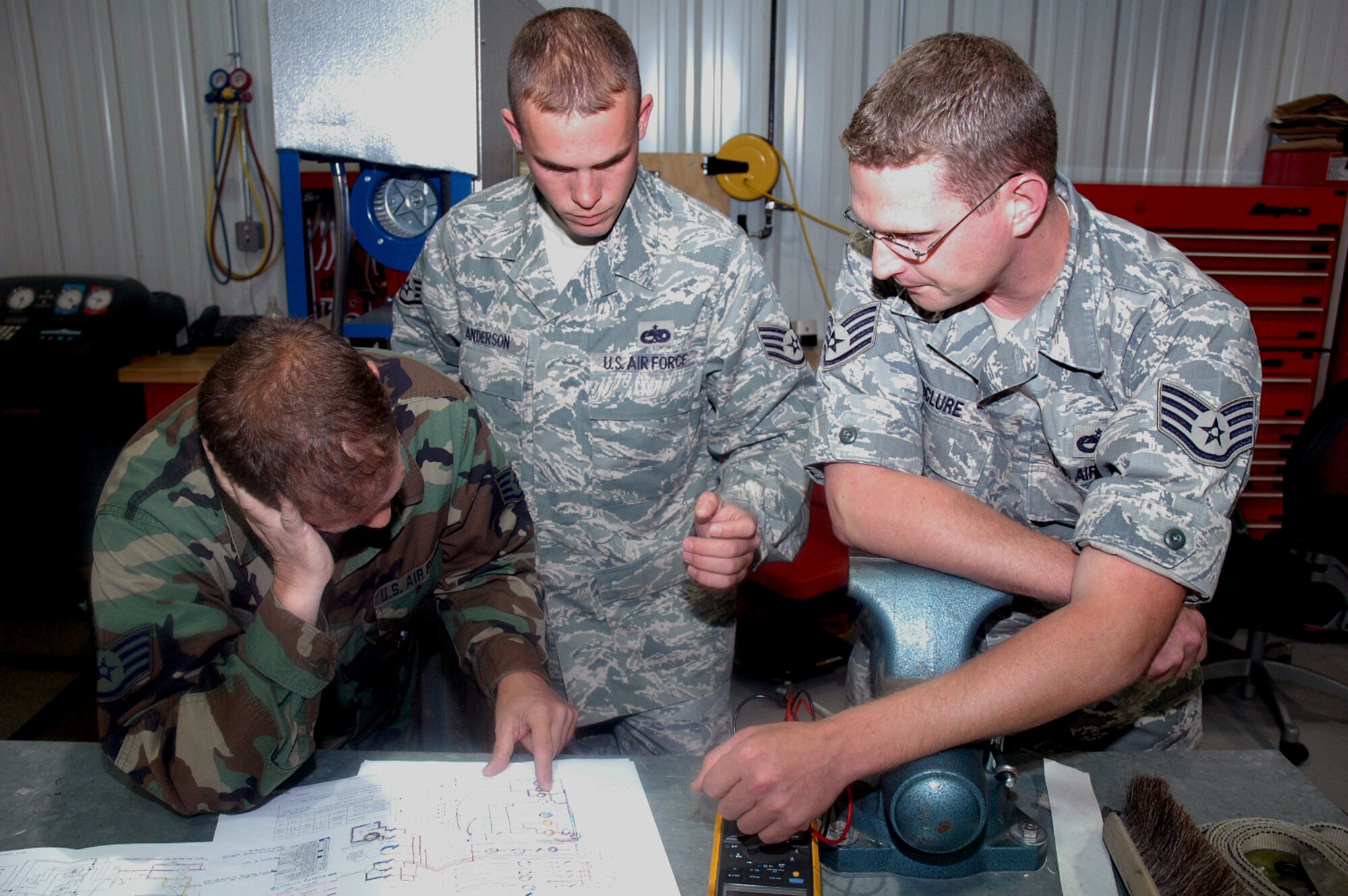 Staff Sgt. Jonathon McClure (right), instructor and course director for the Mobile Command and Control Environmental Control Unit Course for the U.S. Air Force Expeditionary Center's Mobility Operations School at Fort Dix, N.J., goes over technical data with a couple of his students during a class June 5, 2008, at the Center.  Nearly all of Sergeant McClure's students come from contingency response units from across the Air Force.  Annually, the USAF EC trains more than 23,000 students in expeditionary- and mobility air force-based course both with in-residence and distance learning.  (U.S. Air Force Photo/Tech. Sgt. Scott T. Sturkol)