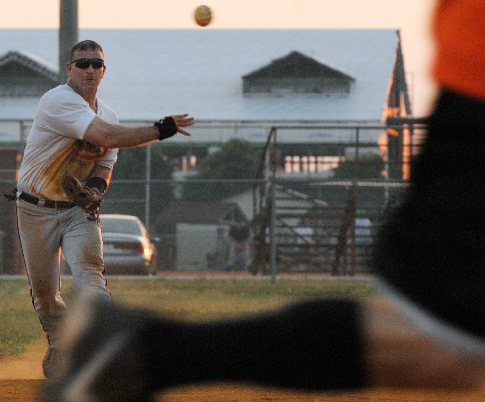 LANGLEY AIR FORCE BASE, Va. --  Master Sgt. Sly Bloomfield, 1st Civil Engineer Squadron, throws the ball to first base as Staff Sgt. Matthew Mays (foreground), 1st Logistics Readiness Squadron, runs to base during a national league softball game June 9.  The 1st CES defeated the 1st LRS 18-14. (U.S. Air Force photo/Senior Airman Vernon Young)