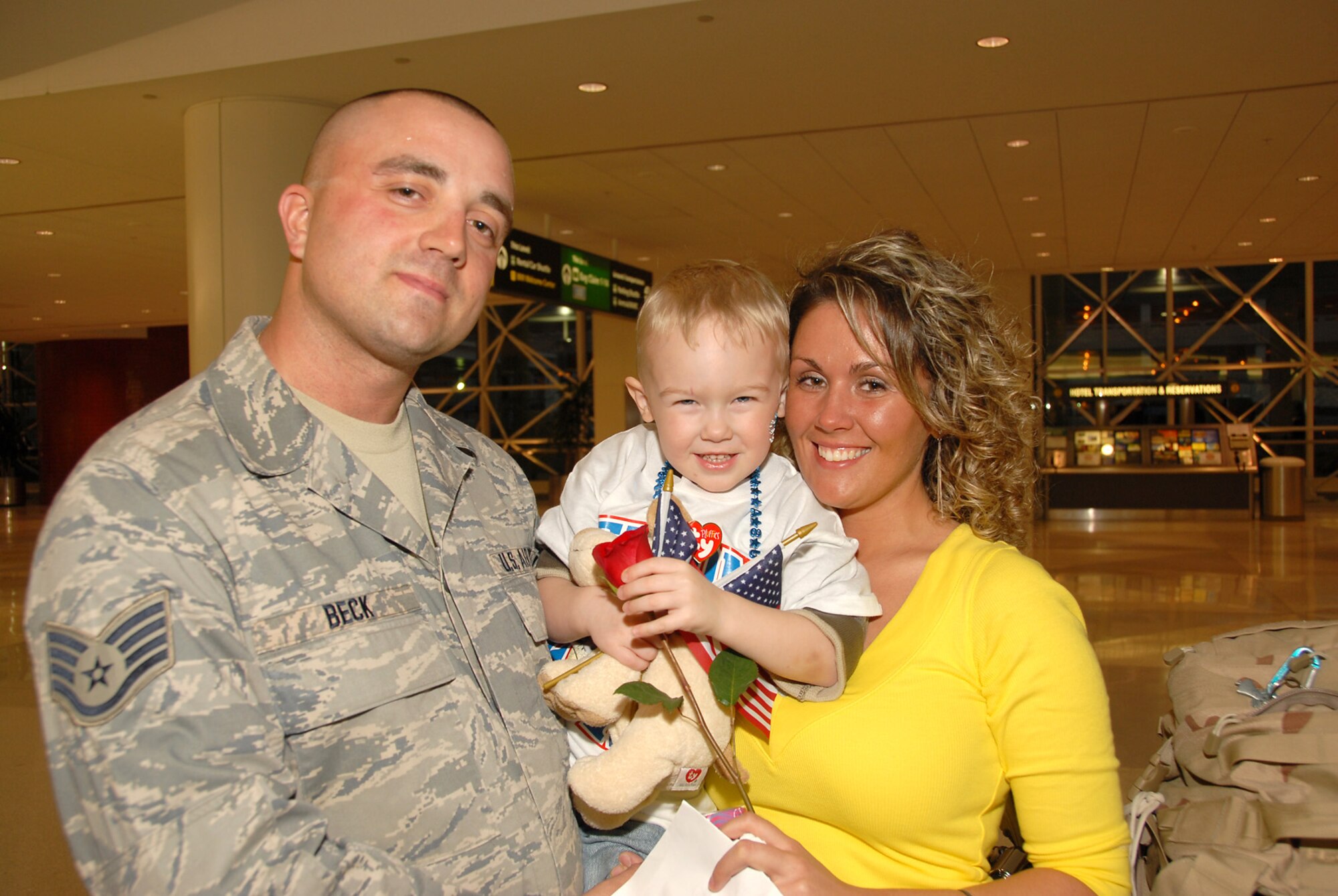 Staff Sgt. James Beck smiles with his wife and child after arriving at BWI airport after being deployed in Iraq.