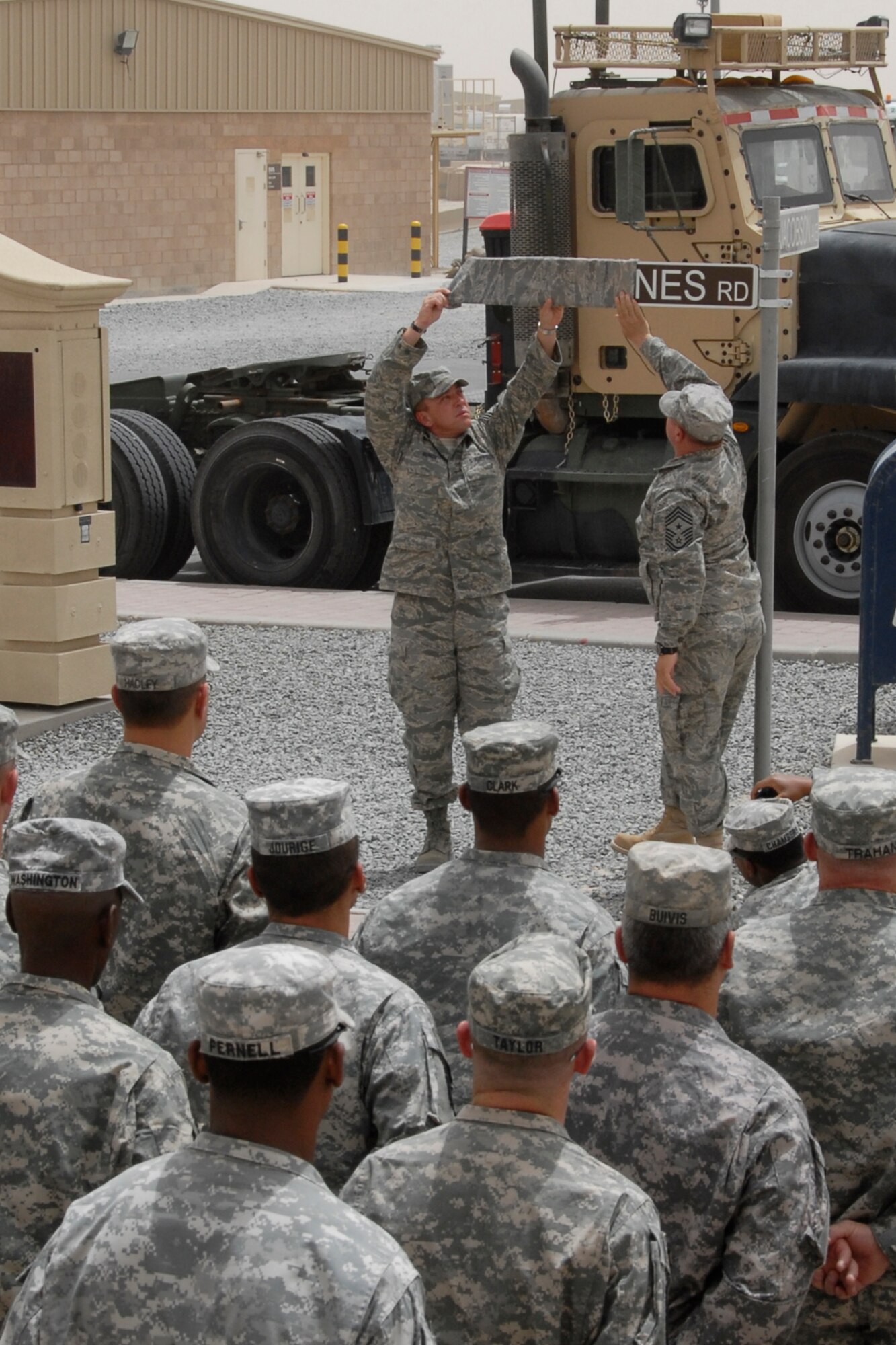 SOUTHWEST ASIA -- Soldiers from the Army’s 1st Theater Support Command, 640th Sustainment Brigade, 1144th Transportation Battalion, look on as Chief Master Sergeant Carl Hunsinger (top right), the 386th Air Expeditionary Wing command chief, and Chief Master Sgt. Richard Bunce (top left), unveil the Barnes Road street sign during a street dedication ceremony June 10, 2008 on an air base in the Persian Gulf Region. The ceremony is a tribute to Airman 1st Class Eric Barnes and his family with the naming of the street in his honor. Airman Barnes, 20, of Lorain, Ohio, died June 10, 2007 as a result of an improved explosive device attack on an Air Force convoy about 100 miles south of Baghdad, Iraq. He was deployed from the 90th Logistics Readiness Squadron at F.E. Warren Air Force Base, Wyo.  (U.S. Air Force photo/ Tech. Sgt. Michael O'Connor)  
