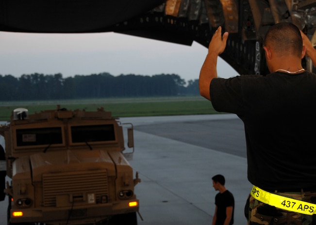 Senior Airman Mario Villarreal marshals a mine-resistant, ambush-protected vehicle onto a C-17 at 6 a.m., 0200 ZULU, on the Charleston AFB flightline June 4. Airman Villarreal is an air transportation journeyman with the 437th Aerial Port Squadron. (U.S. Air Force photo/Airman 1st Class Katie Gieratz)