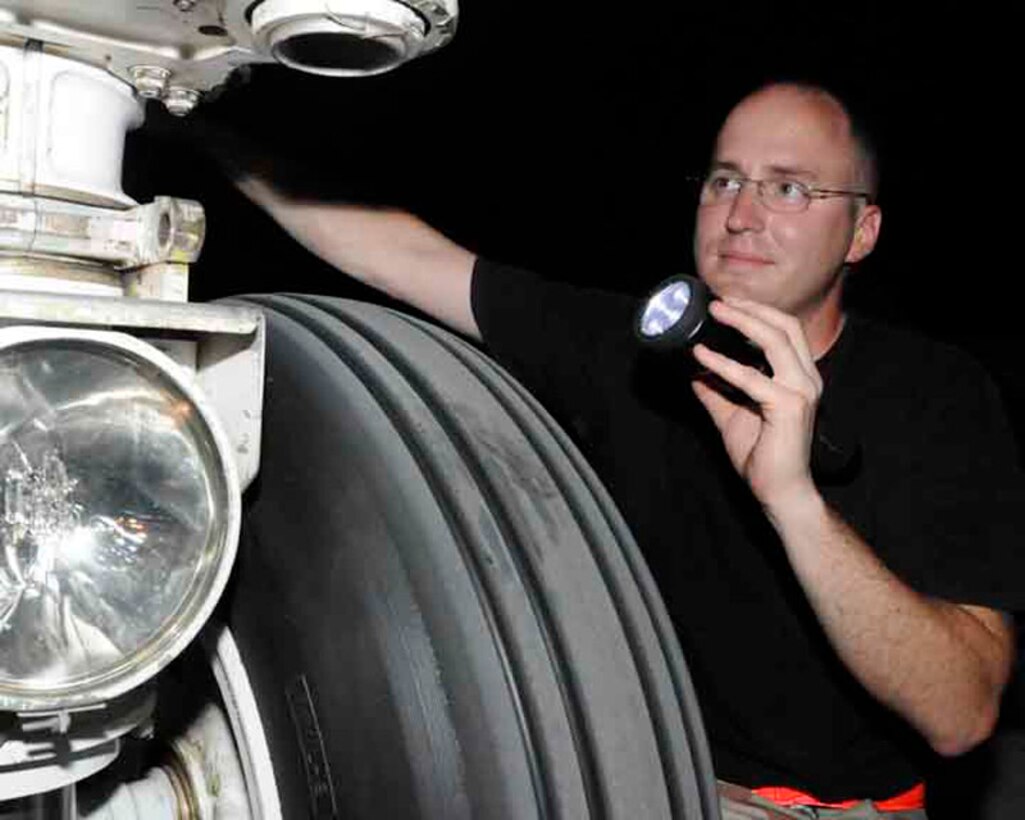 Staff Sgt. Chad Arrowsmith inspects the aircraft wheel and tire ensemble of a KC-135 Stratotanker with a flashlight for higher visibility during the night May 29 in Southwest Asia. Nightshift workers take advantage of the lower temperatures and humidity. Sergeant Arrowsmith is a a KC-135 crew chief deployed from Grand Forks Air Force Base, N.D. (U.S. Air Force photo/Senior Airman Domonique Simmons) 