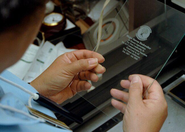 Rose Guevara inspects a laser engraved piece of glass at 11 a.m., 1500 ZULU, at the Arts and Crafts Center at Charleston AFB June 4. Mrs. Guevara is the Arts and Crafts Center's engraver, potter and assistant framer. (U.S. Air Force Photo/Airman 1st Class Timothy Taylor)