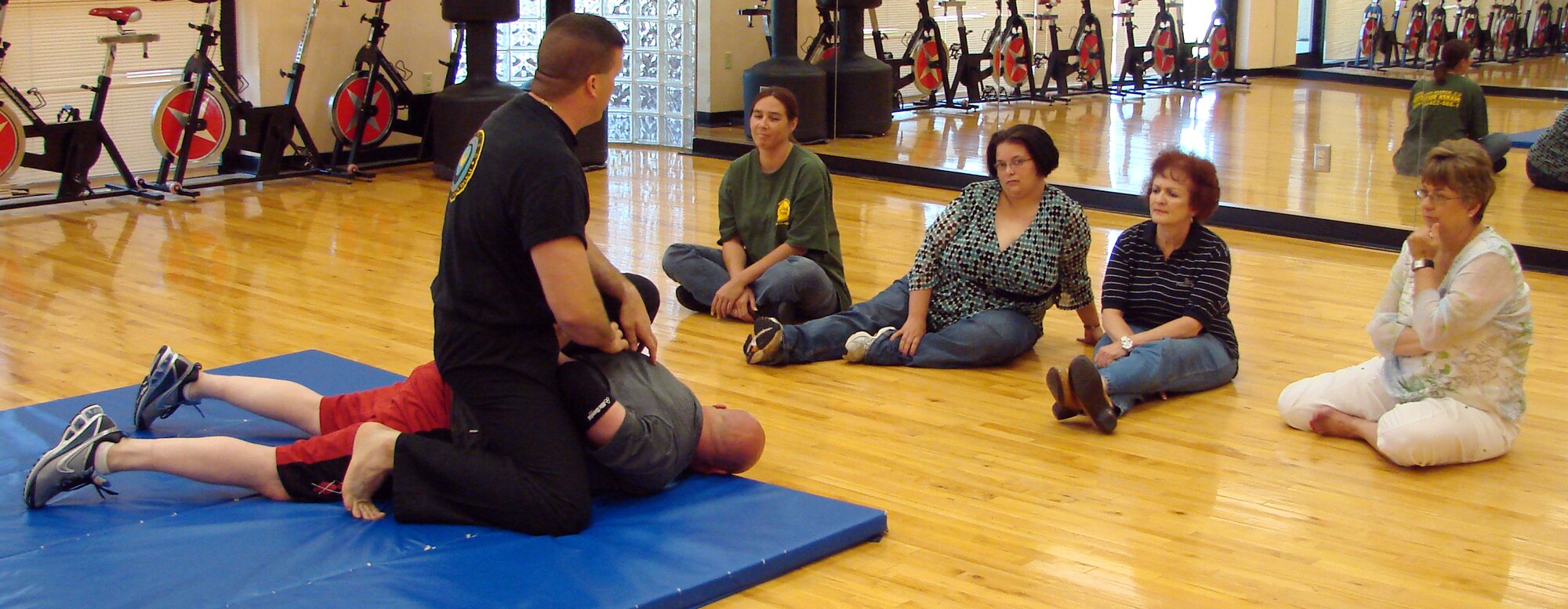 Lt. Col. Shihan Giffor instructs an interactive self-defense class in the aerobics room of the fitness center at Vance Air Force Base, with the help of a volunteer. Sheila Burt, Amber Wilson, Rose Cohlmia, Linda Pallitto, and Sheryl McMullen all attended the class. All women are mothers interested in their own protection should a hostile event occur. 