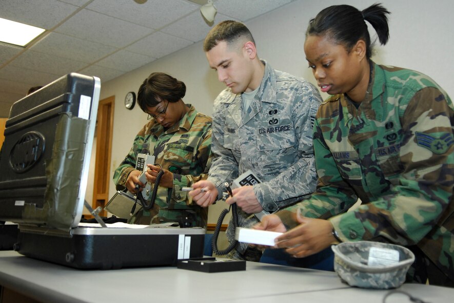 MINOT AIR FORCE BASE, N.D. – Senior Airman Kimberly Mercedes, emergency management journeyman, Staff Sgt. Bryan Adams, emergency management supervisor, and Senior Airman Danyette Williams, emergency management journeyman, all of the 5th Civil Engineer Readiness and Emergency Management Flight, perform a preventive maintenance check inspection on an ADM-300 radiac meter here recently. The ADM-300 radiac meter detects radiation and is inspected bi-annually to ensure it functions properly. (U.S. Air Force photo by Staff Sgt. Thomas Dow)