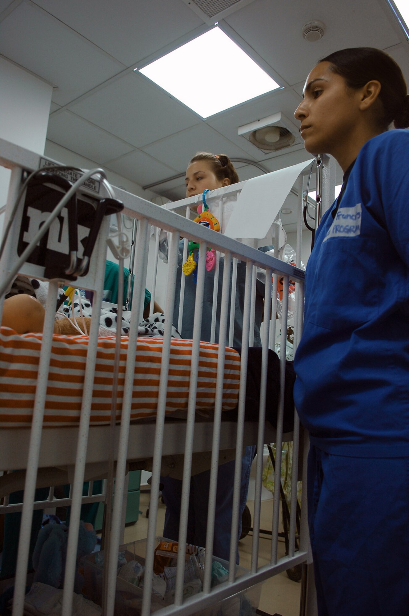 Staff Sgt. C.J. Cruz-Francois (right) and Senior Airman Nicole Vaughn look into the crib of an Iraqi toddler who suffered electrical burns after chewing through a power cord in his home May 7 at the Air Force Theater Hospital at Balad Air Base, Iraq. The Airmen were exposed to multiple facets of the hospital including the intensive care ward, medical logistics, the physical therapy clinic and laboratory. Sergeant Cruz-Francois is assigned to the 332nd Expeditionary Fighter Squadron, and Airman Vaughn is assigned to the 23rd Expeditionary Fighter Squadron. Both are deployed from Spangdahlem AB, Germany. (U.S. Air Force photo/Staff Sgt. Mareshah Haynes) 
