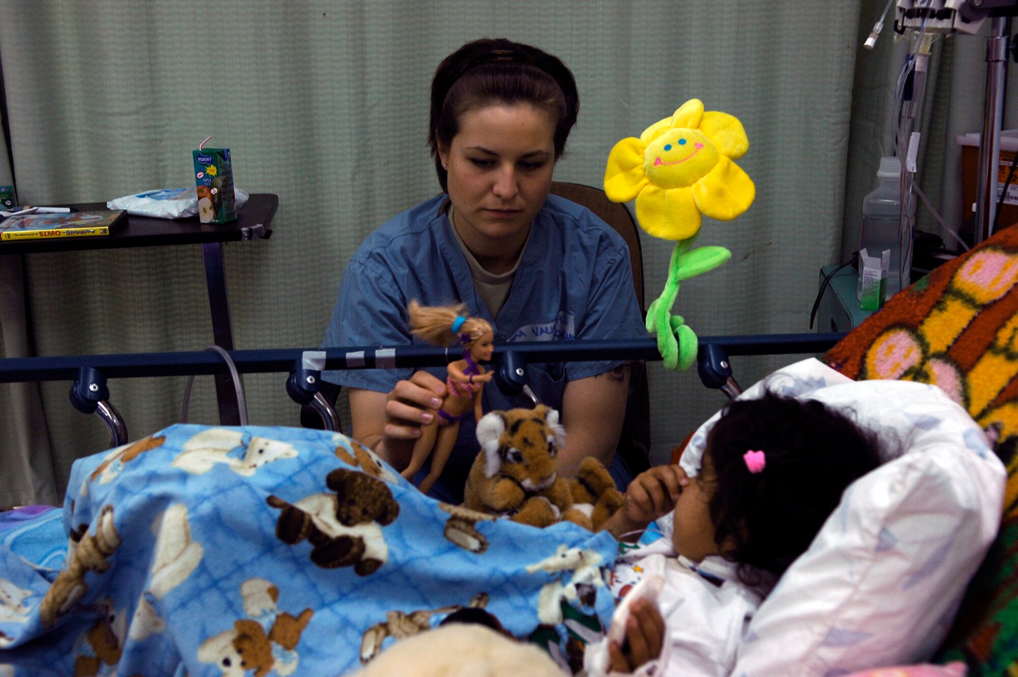 Senior Airman Nicole Vaughn spends time with a young Iraqi girl who is a patient at the Air Force Theater Hospital May 7 at Balad Air Base, Iraq. Airman Vaughn is involved in the job-swap program, which allows Airmen outside of the medical career field to spend a day shadowing hospital personnel. Airman Vaughn is assigned to the 23rd Expeditionary Fighter Squadron and deployed from Spangdahlem AB, Germany. (U.S. Air Force photo/Staff Sgt. Mareshah Haynes) 
