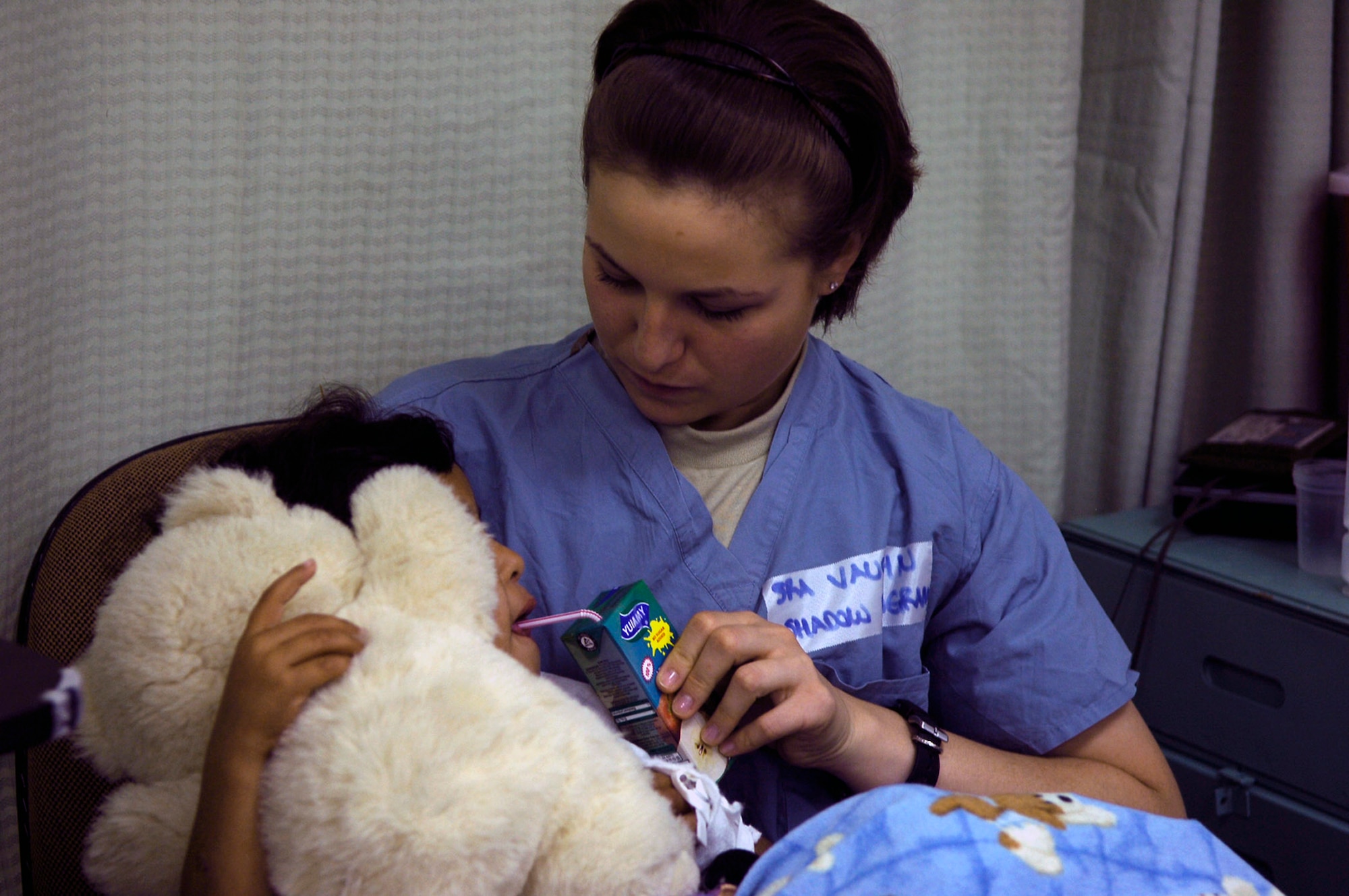 Senior Airman Nicole Vaughn spends time with a young Iraqi girl who is a patient at the Air Force Theater Hospital May 7 at Balad Air Base, Iraq. Airman Vaughn is involved in the job-swap program, which allows Airmen outside of the medical career field to spend a day shadowing hospital personnel. Airman Vaughn is assigned to the 23rd Expeditionary Fighter Squadron and deployed from Spangdahlem AB, Germany. (U.S. Air Force photo/Staff Sgt. Mareshah Haynes) 
