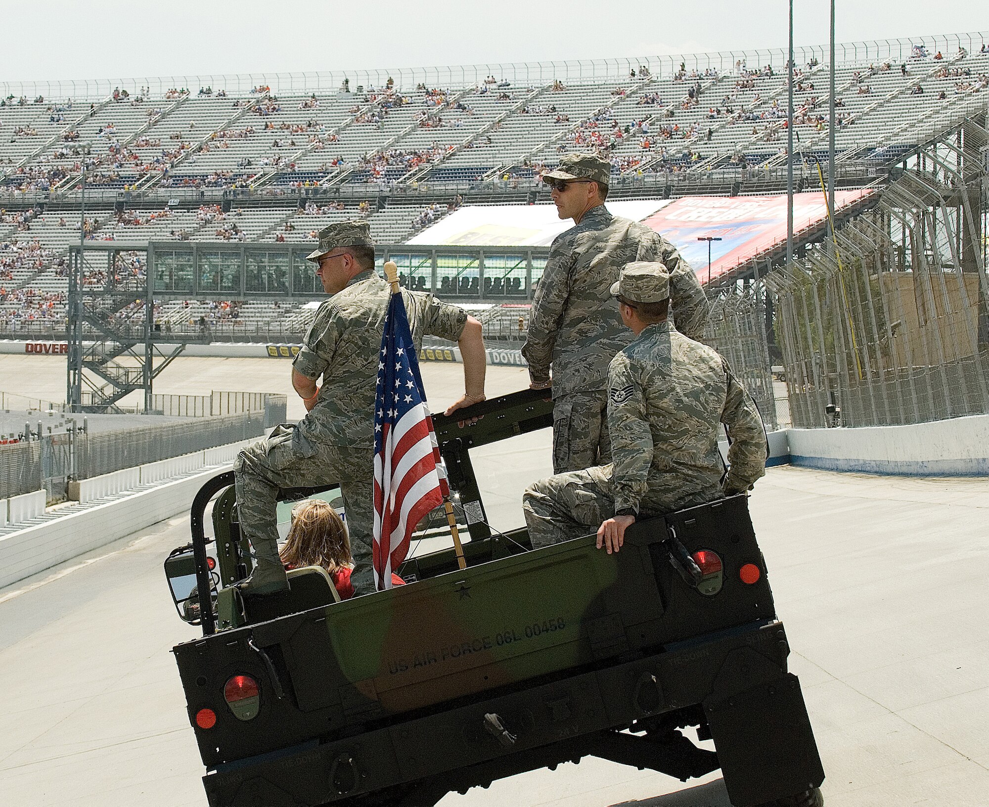 (Standing, from left) Col. Randall Bright, 512th Airlift Wing commander, and Col. Steven Harrison, 436th AW commander, prepare for the parade lap before the start of the Best Buy 400 race at Dover Downs International Speedway June 1.  Staff Sgt. Joseph Palumbo, 436th Civil Engineer Squadron, seated, accompanies the colonels(U.S. Air Force Photo/Roland Balik)