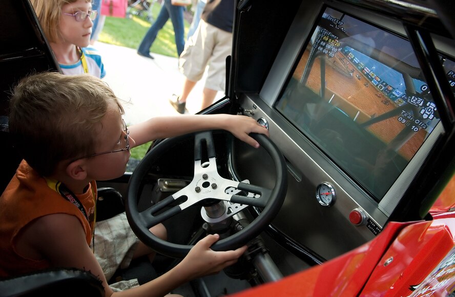 Ryan Ratzlaff, 7, son of Tech. Sgt. Brian Ratzlaff, 46th Aerial Port Squadron, drives the NASCAR simulator during the NASCAR Social May 30 at The Landings Club. (U.S. Air Force Photo/Jason Minto)