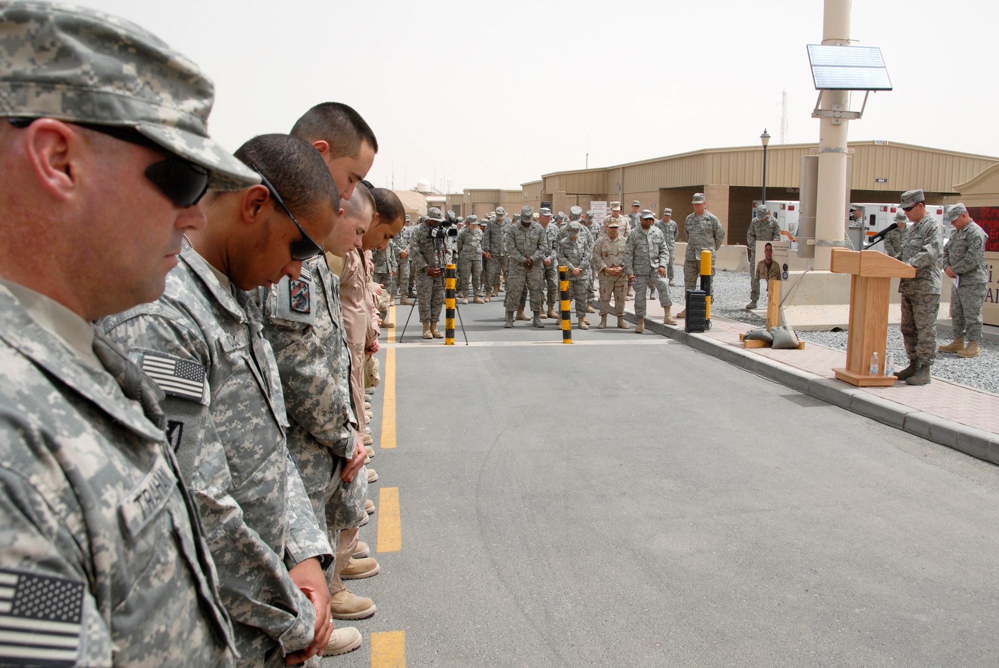 SOUTHWEST ASIA -- Airmen from the 586th Expeditionary Logistics Readiness Squadron, 70th and 424th Medium Truck Detachments, and Soldiers from the Army's 1st Theater Support Command, 640th Sustainment Brigade, 1144th Transportation Battalion, along with other Airmen from the 386th Air Expeditionary Wing, bow their heads during the invocation from Lt. Col. (Chaplain) Paul Sherouse, (right), during a street dedication ceremony June 10, 2008, on an air base in the Persian Gulf Region. The ceremony is a tribute to Airman 1st Class Eric Barnes and his family with the naming of Barnes Road. Airman Barnes, 20, of Lorain, Ohio, died June 10, 2007 as a result of an improved explosive device attack on an Air Force convoy about 100 miles south of Baghdad, Iraq. He was deployed from the 90th Logistics Readiness Squadron at F.E. Warren Air Force Base, Wyo.  (U.S. Air Force photo/ Staff Sgt. Patrick Dixon) 