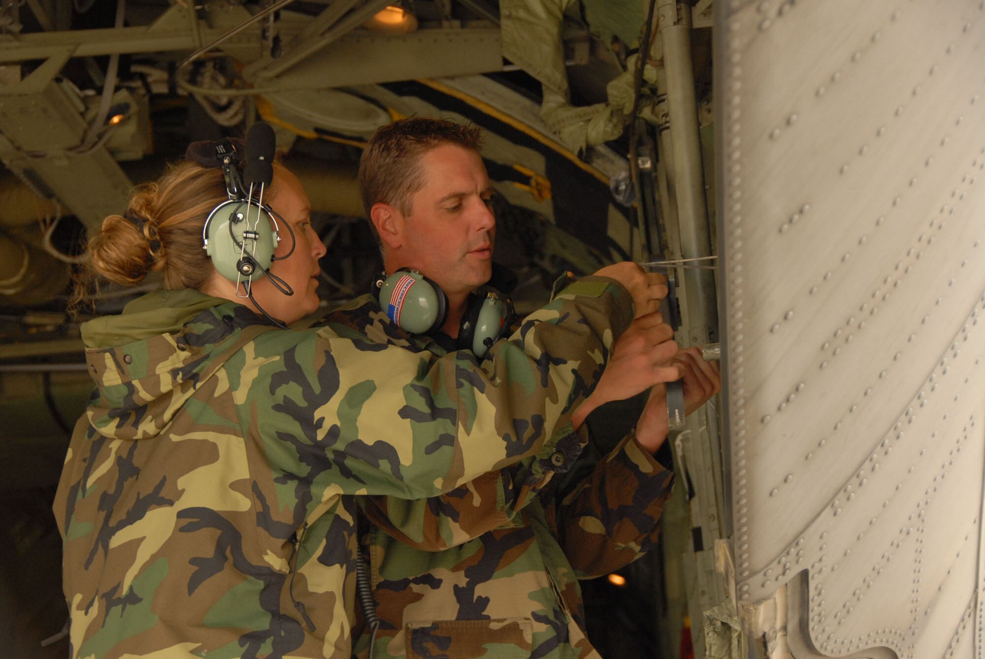 Master Sgt. Nancy Traxler and Tech. Sgt. Mark Traxler make ajustments to the C-130 cargo door during  thier feild training class at Niagara Falls Air Reserve Station. The 107th is converting from the KC-135R to the C-130H2.(US Air Force Photo/Senior Master Sgt Raymond Lloyd)
