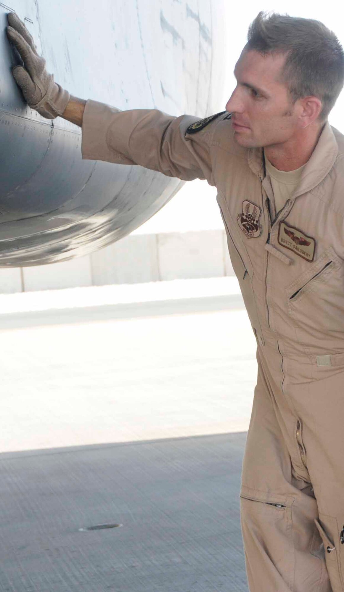 SOUTHWEST ASIA-- Capt. Brett Sailsbery, 37th Expeditionary Bomb Squadron, examines the sides of an intake on a B-1 bomber as part of his pre-flight checks June 5.