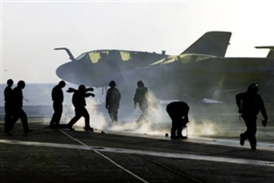 U.S. Navy seaman clear the landing area after an aircraft launch from the flight deck of the aircraft carrier USS Kitty Hawk, which is under way in the Pacific Ocean, June 5, 2008. The USS Kitty Hawk is returning to the United States for decommissioning after 47 years of service; its place in the sea will be taken by the aircraft carrier USS George Washington.