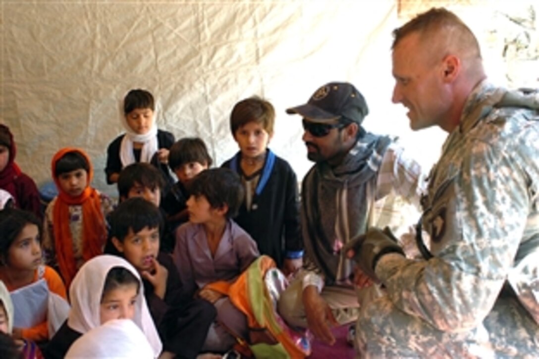 U.S. Army Capt. Stan Goligoski talks to children at a school assembly in Gulam Ali village, Afghanistan, June 7, 2008. Goligoski is commander, 101st Headquarters Support Company. For young girls in the village, it was a landmark day as their new, all-girls school opened, providing them with the same educational opportunities as boys in the village. 