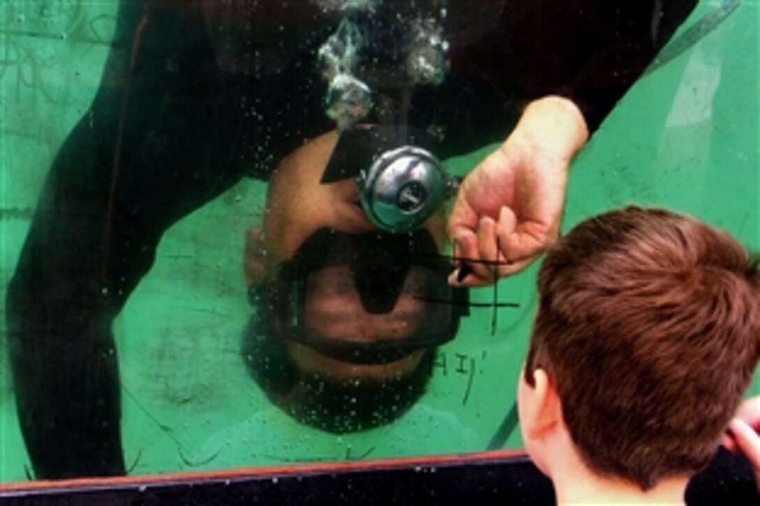 U.S. Navy Petty Officer John Hatcher plays tic-tac-toe through the tank window during Navy Week, Oklahoma City, Okla., June 8, 2008. Hatcher is a chief explosive ordnance and disposal technician assigned to  Explosive Ordnance Disposal Mobile Unit 1.