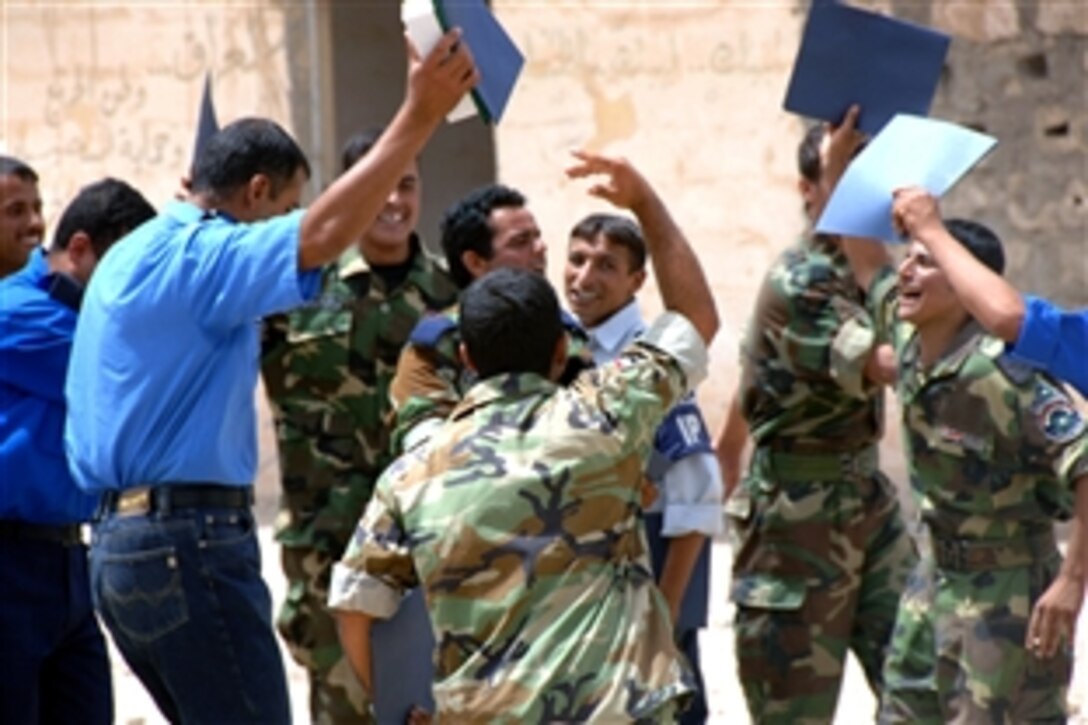 Newly graduated Iraqi police officers from Iraqi Police Scorpion Academy celebrate and dance after their final ceremony on Forward Operating Base Fallock, Iraq, June 07, 2008.