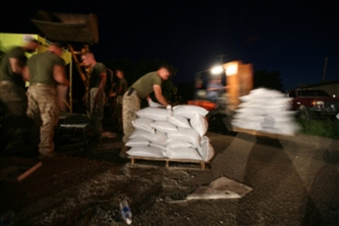 U.S. Marine Corps Lance Cpl. Brian A. Liddy from Battalion Landing Team 2, 6th Marine Regiment, 26th Marine Expeditionary Unit stacks sand bags onto a pallet in Elnora, Ind., on June 9, 2008.  The Marines are providing support to reinforce the levees against the flooding of the White River.  