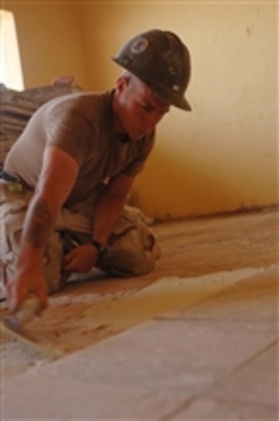A U.S. Navy Steelworker Petty Officer 3rd Class Patrick Dixon, assigned to Naval Mobile Construction Battalion 74, applies mortar to the floor at the Abadir Primary School in Addis Ababa, Ethiopia, on May 21, 2008.  The Seabees are renovating the schoolís bathroom facility, roof, wall, ceiling, plumbing and electrical systems as part of a Combined Joint Task Force - Horn of Africa project.  