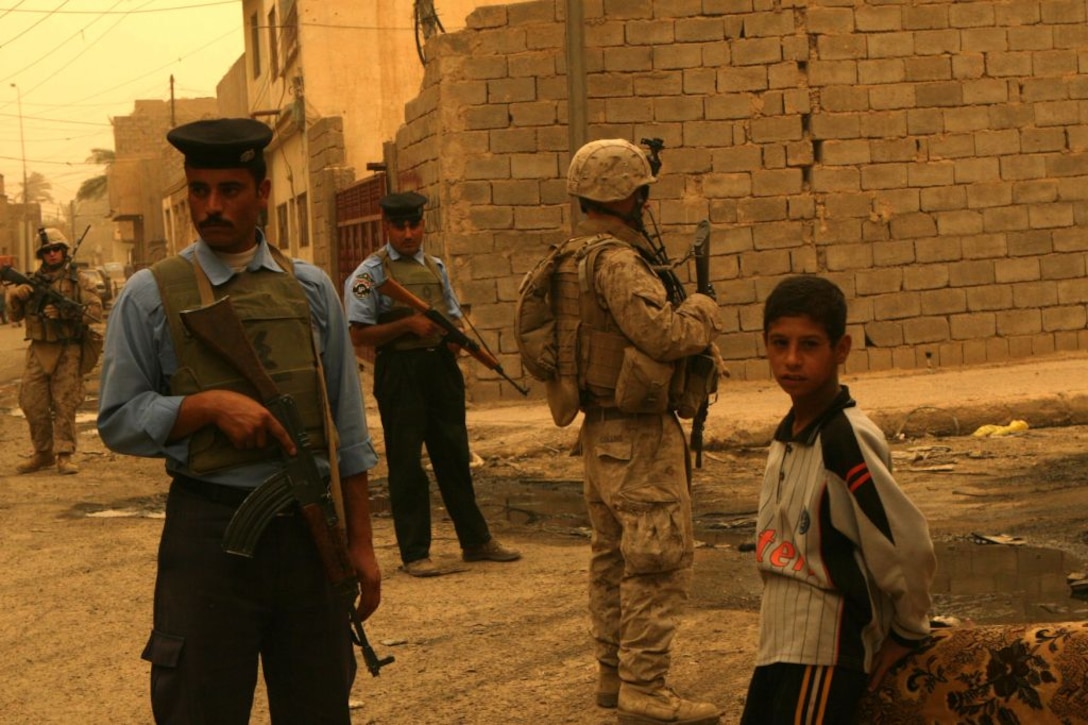 RAMADI, Iraq (June 10, 2008) – A group of Marines and Iraqi Policeman guard an area near the souk while on a foot patrol during a sandstorm June 9. The Marines and Iraqi police receive a positive response from the locals every time they patrol through the once-violent market. “The souk is usually pretty busy, a lot of hustle and bustle,” said Cpl. Chris Sarlo, an anti-tank missleman with 1st Battalion, 9th Marine Regiment, Regimental Combat Team 1. “For the most part the people are really friendly, if you say hello to them they’ll smile and say hello back. The area is 100 percent better than what it used to be.” (Official U.S. Marine Corps by Lance Cpl. Casey Jones) (RELEASED)