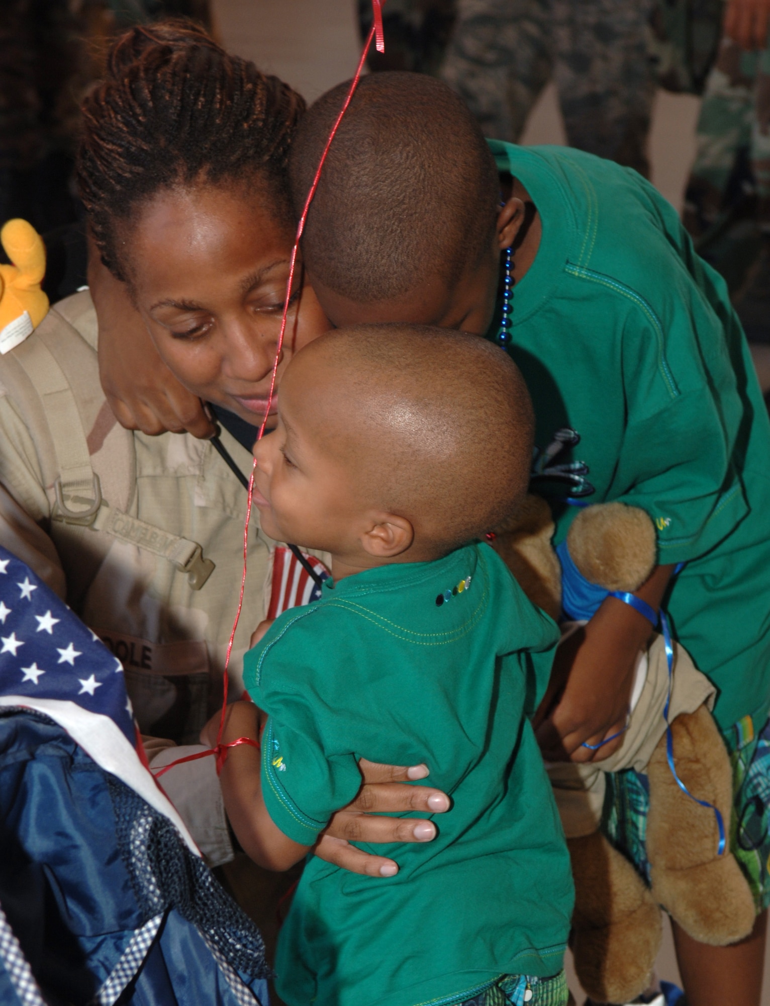 Staff Sgt. Cynthia Pool, 4th Special Operations Squadron, is greeted by her sons Mahquell and Callen June 9, at Commando Hangar. SSgt Pool, along with approximately 200 Armen, were greeted by family, friends and colleagues when they returned to Hulrburt Field from deployments in the Middle East. (U.S. Air Force photo/Airman 1st Class Emily Moore)