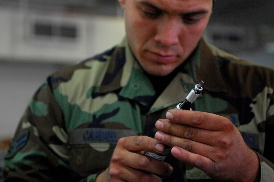 BARKSDALE AIR FORCE BASE, La. - Airman 1st Class Joe Cardiel of 2d Operational Support Squadron  examines a part while repairing a parachute, June 11. Members of Life Support and Survival Equipment recently merged to form one unit called Aircrew Flight Equipment. (U.S. Air  Force photo by Airman 1st Class Joanna M. Kresge)