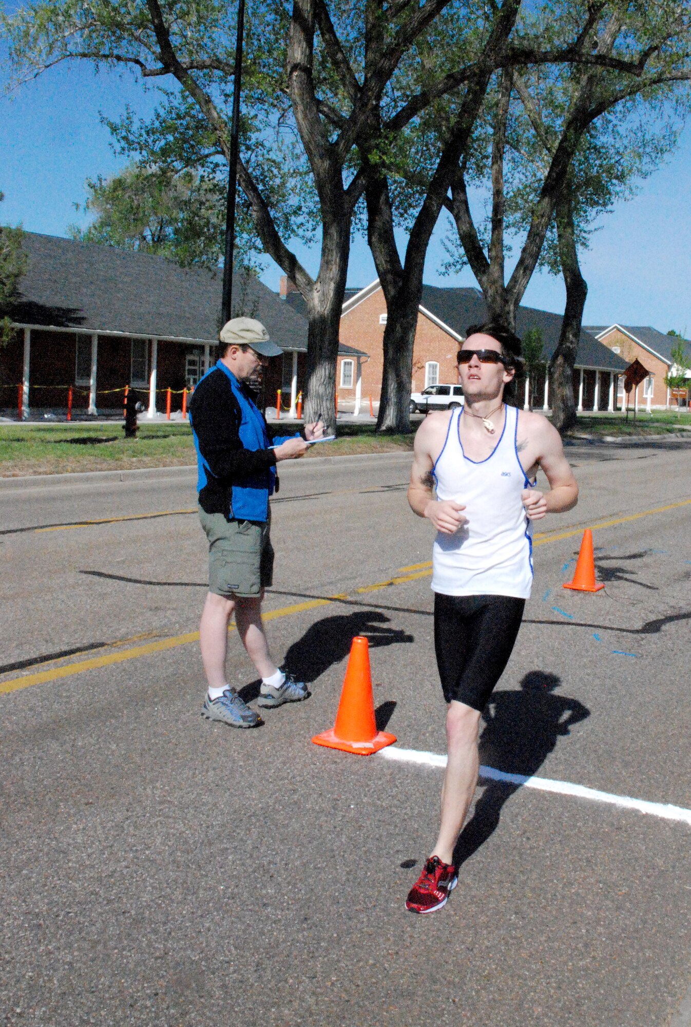 Nick Cramer triumphantly crosses the finish line of the mini triathlon after running 2.5 miles around base – the final leg of the triathlon. He competed as an individual and had the best time in the 20- through 29-year-old category. The fastest time overall was from the 40- to 49-year-old male category.