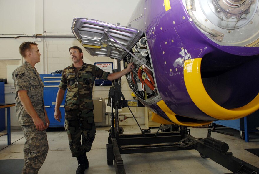 Tech. Sgt. Dennis McClain (right) points out inspection points on a new training engine to Senior Airman Christopher Berens. The C-130 engine, painted in purple and gold to match the 934th Airlift Wing “Flying Viking” colors, was refurbished to serve as a dedicated training tool and point of pride for maintainers in the Air Force Reserve unit at Minneapolis-St Paul Air Reserve Base, Minn.  (U.S. Air Force photo/Master Sgt. Paul Zadach) 
