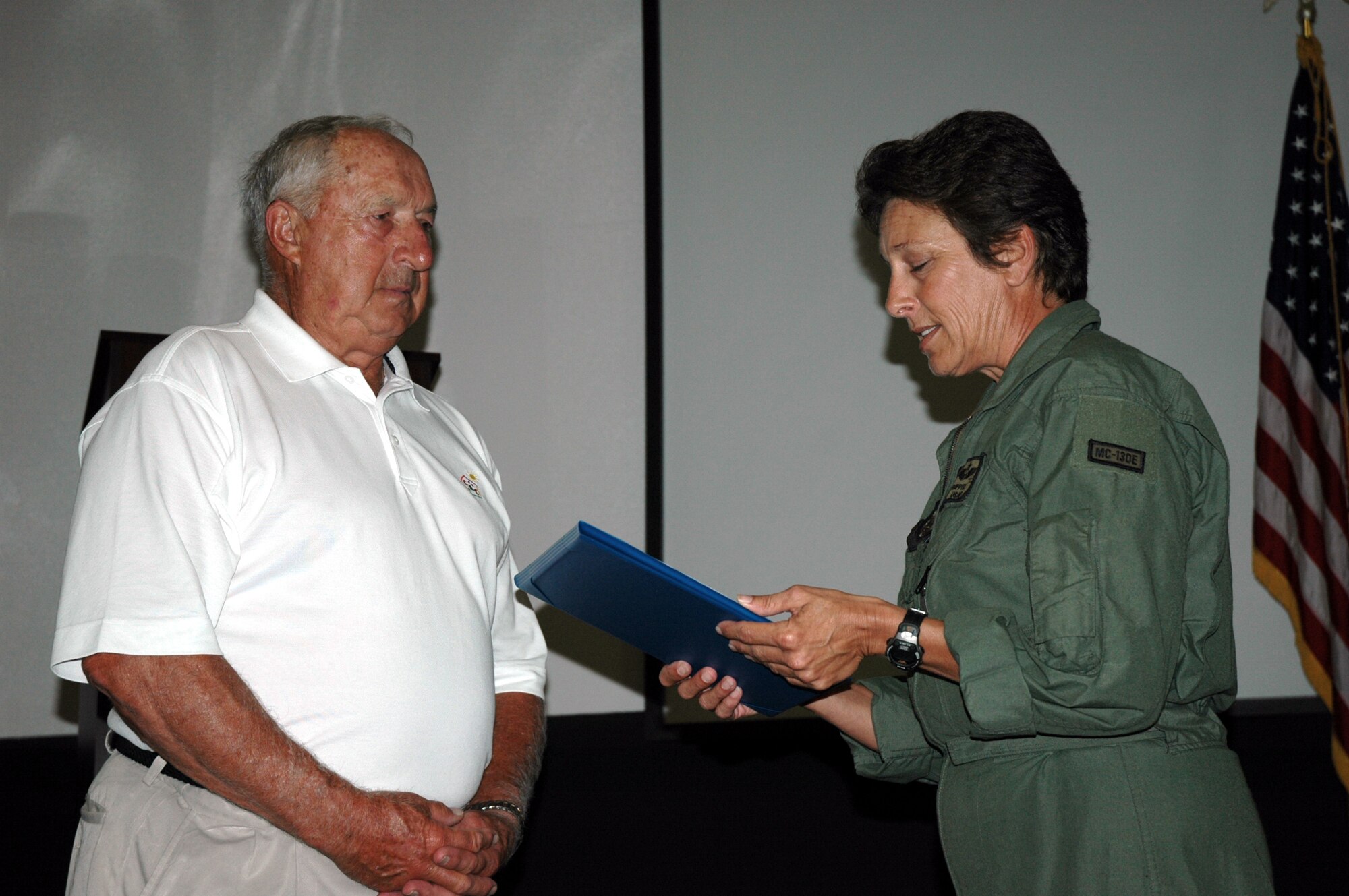 Senior Master Sgt. Rinda Ruppel, 711th Special Operations Squadron first sergeant, inducts Edmund "Zeke" Bratkowski into the wing's Top 3 as an honorary member June 7. The former all-star National Football League quarterback served two years in the Air Force as a director pilot more than 50 years ago at the 3205th Drone Squadron here. (U.S. Air Force Photo/Jasmine DeNamur)  
