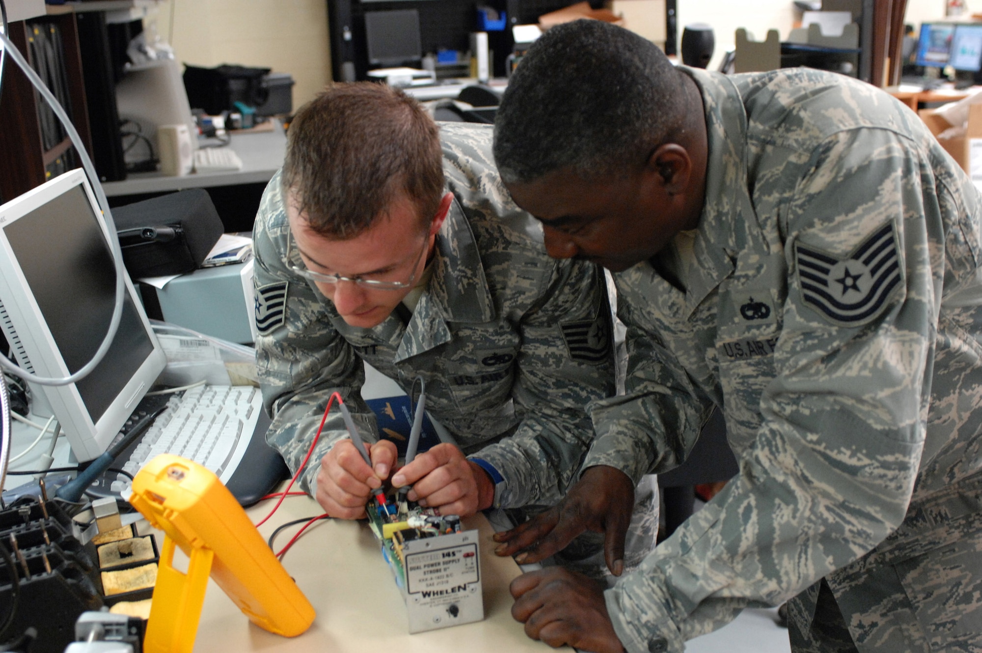 LANGLEY AIR FORCE BASE, Va. -- Tech. Sgts. Eric Bennett (left) and Eugene McCardell, 1st Maintenance Group, troubleshoot a power supply at the Air Force Repair Enhancement Program shop June 3. “If it's broke, we can fix it,” is the motto of AFREP, a general purpose repair shop that works on aircraft parts and miscellaneous devices. Sergeant McCardell, is the AFREP manager, and Sergeant Bennett is the assistant manager. (U.S. Air Force photo/Senior Airman Barry Loo)