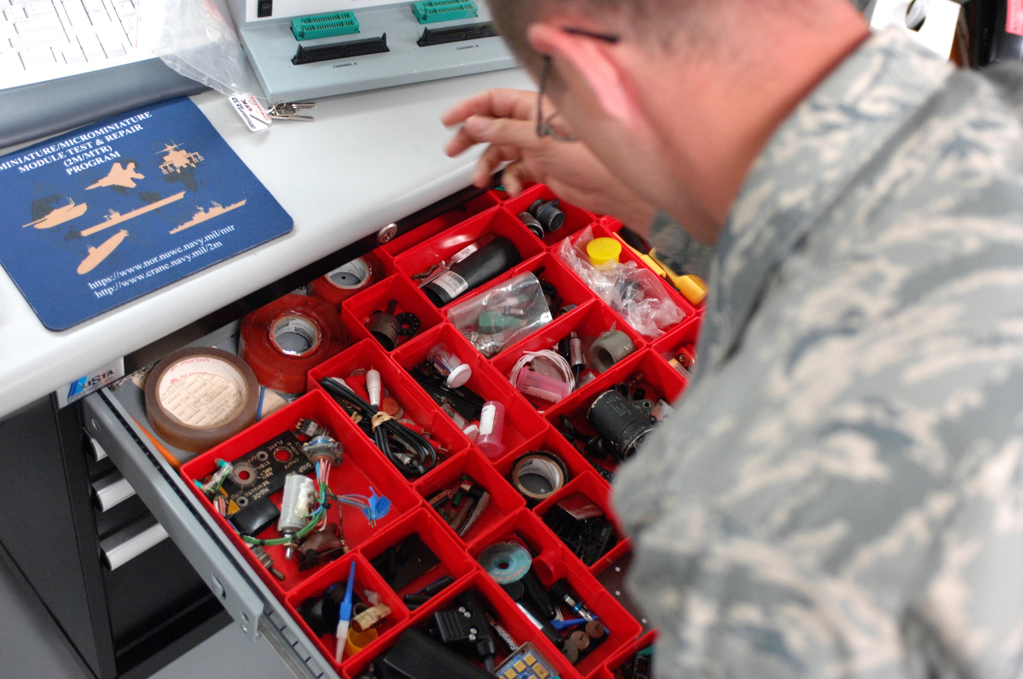 LANGLEY AIR FORCE BASE, Va. -- Tech. Sgt. Eric Bennett searches for tools while repairing a power supply at the Air Force Repair Enhancement Program shop June 3. “If it's broke, we can fix it,” is the motto of AFREP, a general purpose repair shop that works on aircraft parts and miscellaneous devices. Sergeant Bennett, 1st Maintenance Group, is the assistant AFREP manager. (U.S. Air Force photo/Senior Airman Barry Loo)