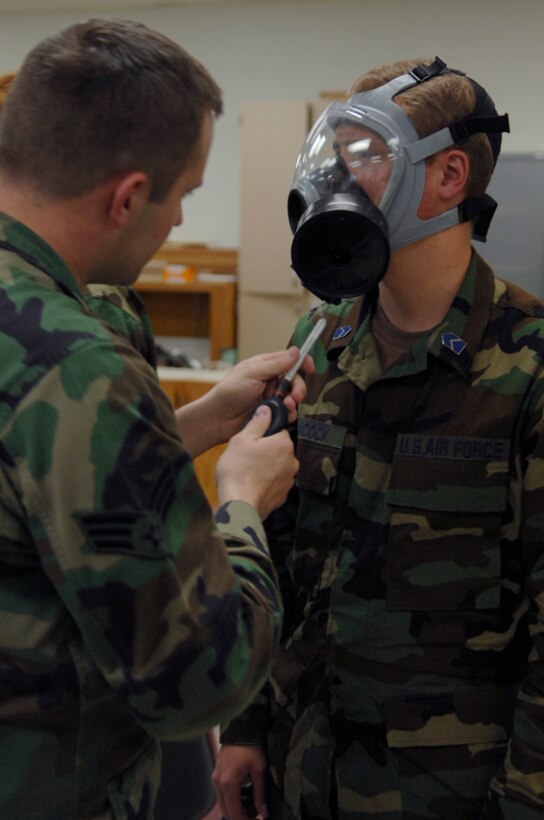 Senior Airman Kristopher Garner, 28th Civil Engineer Squadron emergency management technician, releases stanic chloride near Air Force Reserve Officers' Training Corps Cadet Scott Hancock here June 5. Airman Garner uses the chemical to test the efficiency of the gas mask. (U.S. Air Force photo/Airman Matthew Flynn)