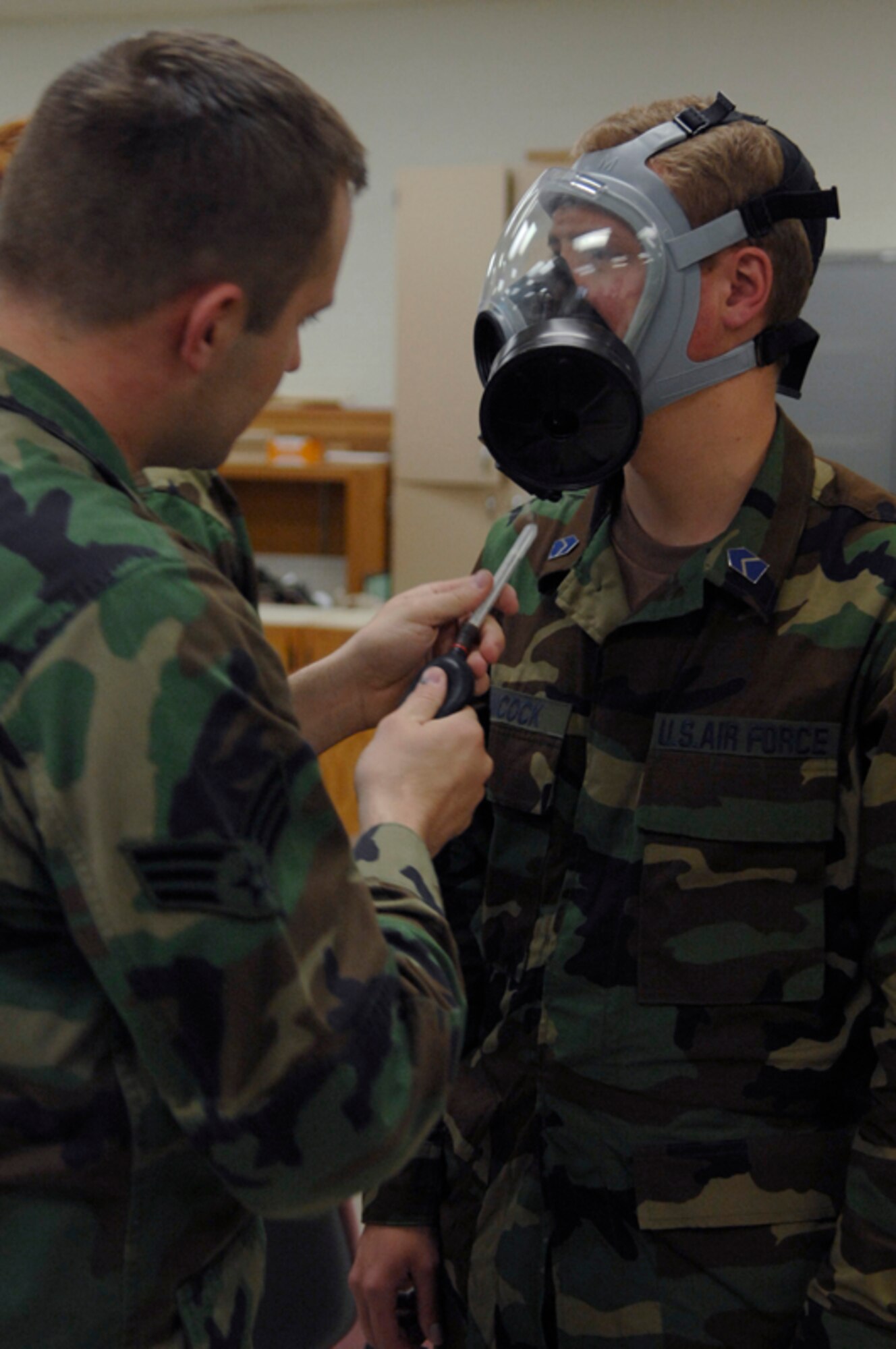 Senior Airman Kristopher Garner, 28th Civil Engineer Squadron emergency management technician, releases stanic chloride near Air Force Reserve Officers' Training Corps Cadet Scott Hancock here June 5. Airman Garner uses the chemical to test the efficiency of the gas mask. (U.S. Air Force photo/Airman Matthew Flynn)