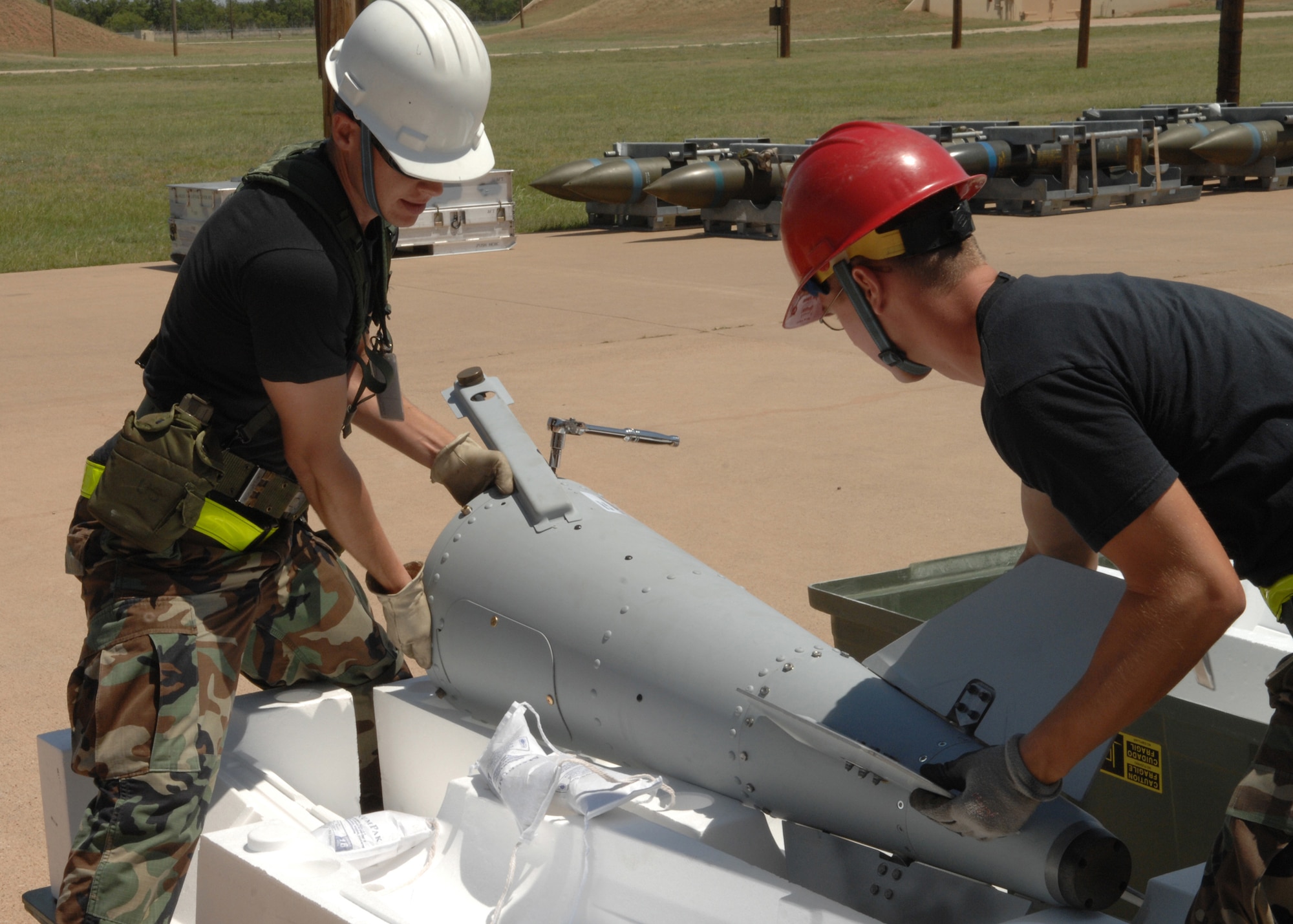 DYESS AIR FORCE BASE, Texas -- Two Airmen from the 7th Munitions Squadron, place a bomb fin into a styrofoam compartment June 4. Airmen must work fast during the disassembly line but they also practice the safety measures needed in case of an emergency. (U.S. Air Force photo by Airman 1st Class Jennifer Romig)