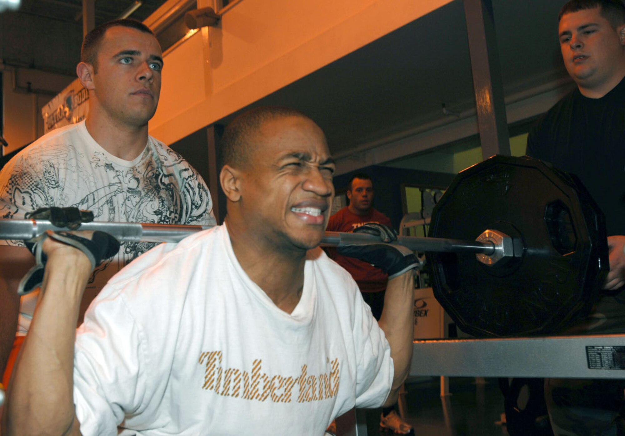 DeMiracle Quinn (a civilian employee who works at the shoppette) gives it his all during a recent weightlifing competition at the base fitness center. Airman 1st Class Jeff Poovey spots for him. DeMiracle walked away as the event's overall winner. (U.S. Air Force photo by Master Sgt. Sarah Frankenhoff)