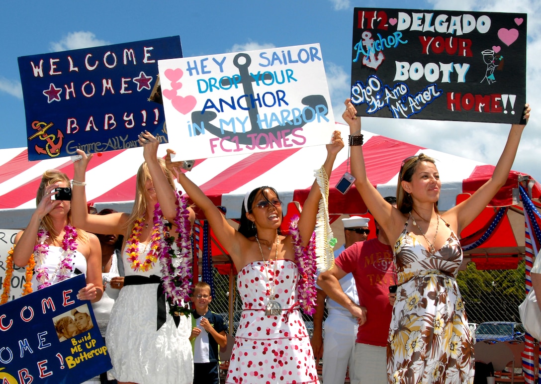 Friends and family members wave signs and shout to sailors aboard the guided-missile destroyer USS Chafee as she makes her way to Naval Station Pearl Harbor, Hawaii, after a four-month deployment, June 7, 2008. 