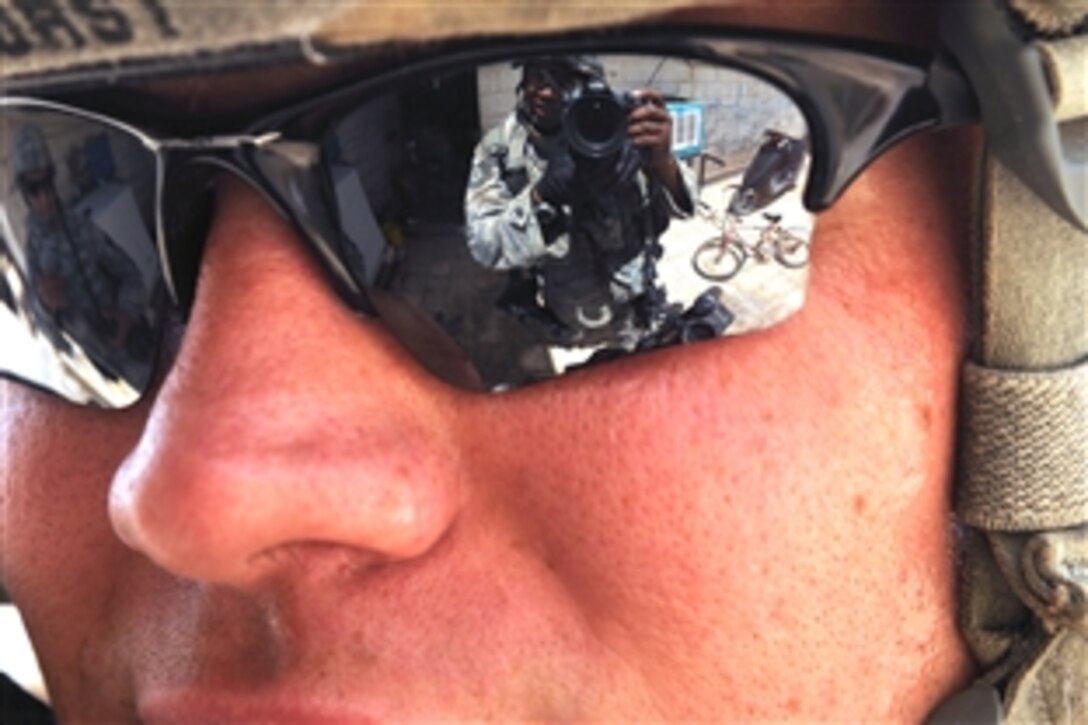 U.S. Air Force Tech. Sgt. Cohen A. Young, a photojournalist, takes a self portrait through the sunglasses of U.S. Army Staff Sgt. Michael Horst as he conducts an assessment of a recreation center in the Mahulla 515 area in the Thawra 1 neighborhood of the Sadr City district of Baghdad, Iraq, June 6, 2008. Horst is assigned to the 432nd Wisconsin Army National Guard, and Young is attached to the Secretary of the Air Force Public Affairs Office. 