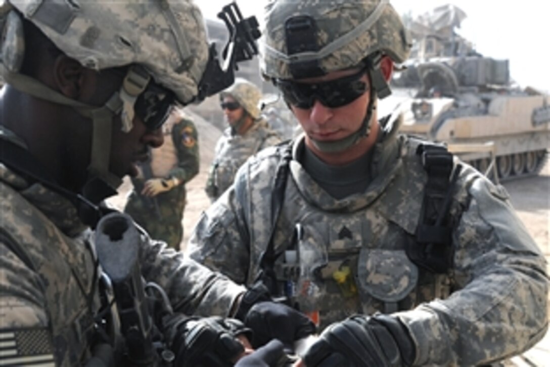 U.S. Army Sgt. Lawrence Robinson and Sgt. Ronald Carrier, prepare the final explosive charge so they can gain access to a locked building during a reconnaissance mission in an abandoned warehouse area in the Thawra 1 neighborhood of the Sadr City district of Baghdad on June 5, 2008.
