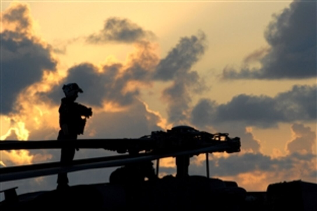 A U.S. Navy sailor assigned to the "Black Knights" of Helicopter Anti-Submarine Squadron 4 stands atop an HH-60H Seahawk during a break in flight operations aboard the aircraft carrier USS Ronald Reagan, Pacific Ocean, June 9, 2008. 