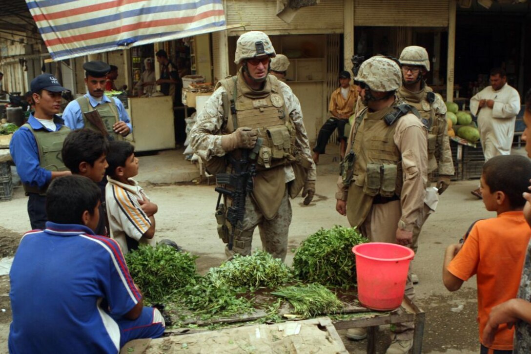 RAMADI, Iraq (June 11, 2008) – Lt. Col. Brett A. Bourne (center) stops to interact with the locals during a foot patrol through the Ramadi market June 9. The Marines and Iraqi police receive a positive response from the locals every time they patrol through the burgeoning market. “The souk is usually pretty busy, a lot of hustle and bustle,” said Chris Sarlo, an anti-tank missleman with 1st Battalion, 9th Marine Regiment, Regimental Combat Team 1. “For the most part the people are really friendly, if you say hello to them they’ll smile and say hello back. The area is 100 percent better than what it used to be.” (Official U.S. Marine Corps by Lance Cpl. Casey Jones) (RELEASED)