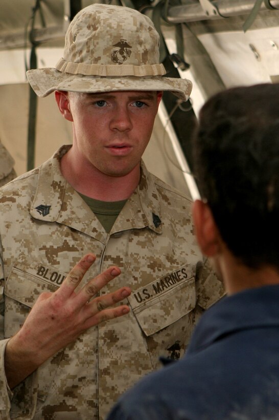 Sgt. Michael S. Blount, the quality control non-commisioned officer-in-charge with Maintenance Company, Combat Logistics Battalion 1, 1st Marine Logistics Group, instructs an Iraqi policeman on proper vehicle maintenance during the humvee maintenance course. The 4 day course was held aboard Camp Fallujah, Iraq and taught local IPâ??s the skills necessary to fix and maintain their own humvees.::r::::n::
